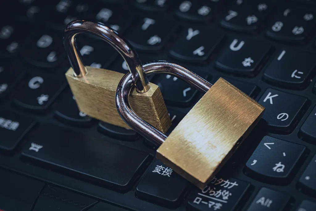 Brass padlock resting on a black laptop keyboard